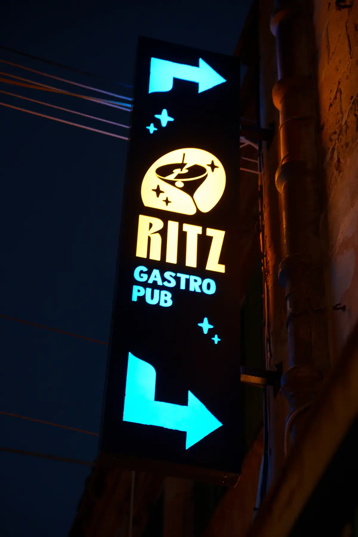 The Ritz Gastro Pub blade sign with arrows pointing the way in