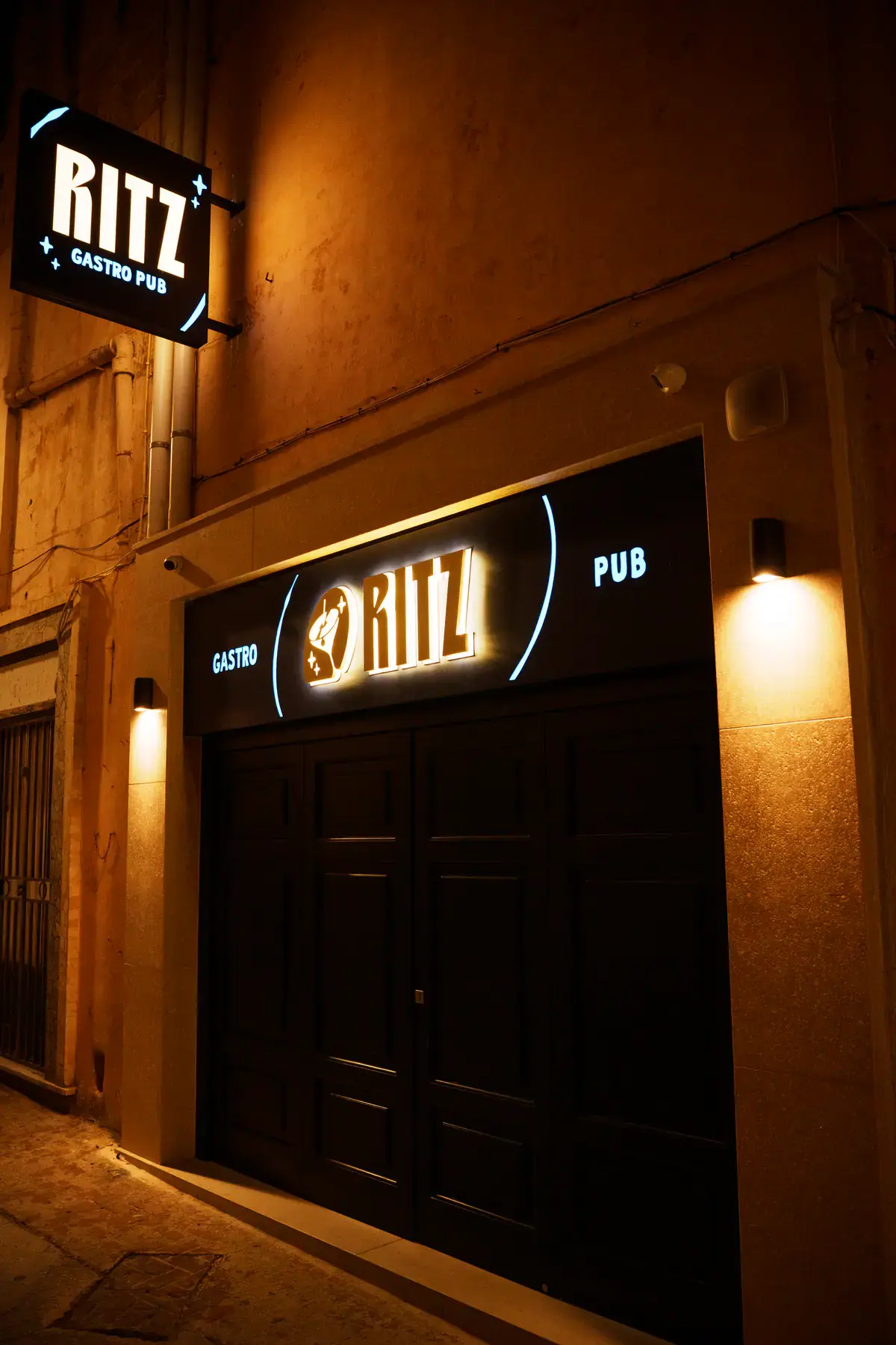 The Ritz entrance and hanging sign on a Victoria street at night