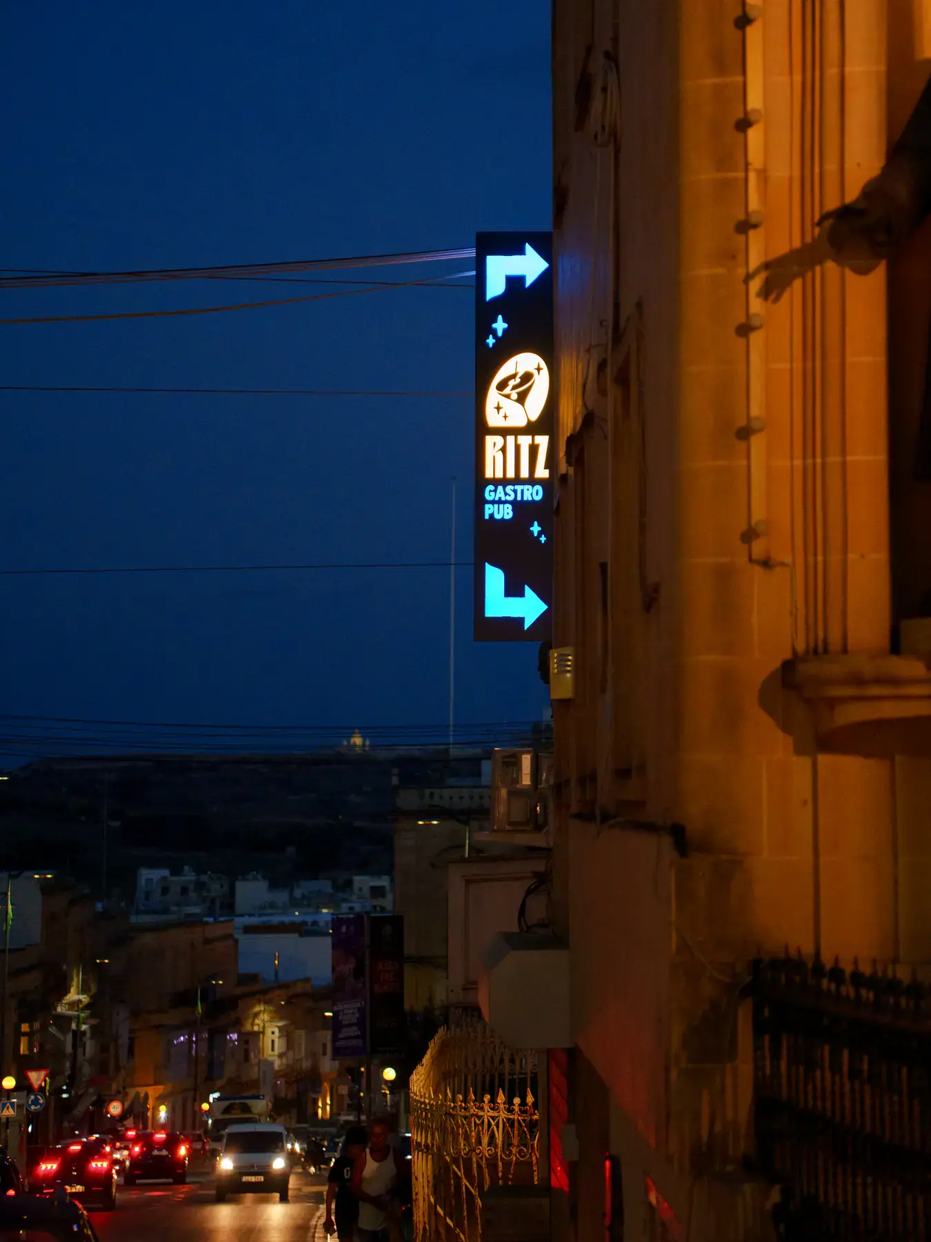 Looking down a Victoria street at night, past the Ritz sign