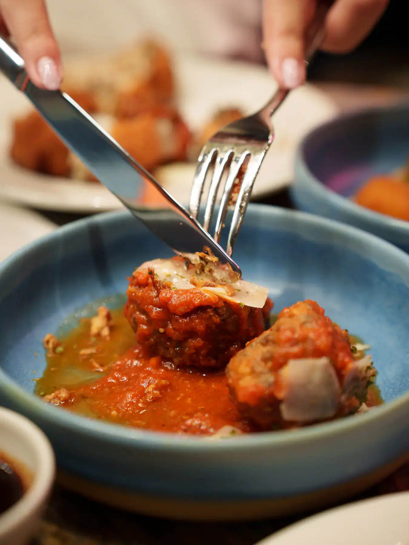 Meatballs in tomato sauce, served in a blue bowl