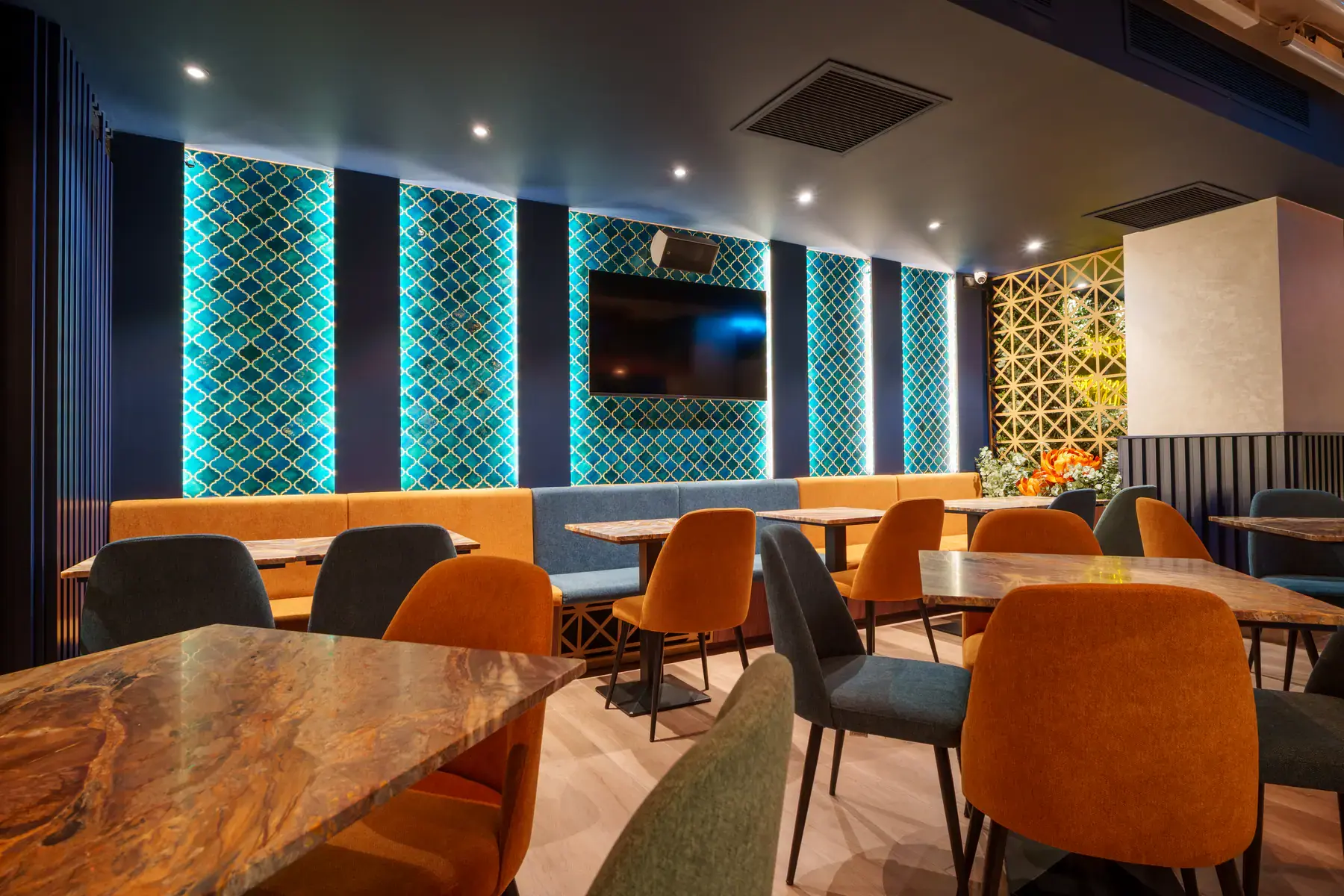 Teal tiled walls and banquette seating